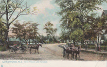 Load image into Gallery viewer, Vintage postcard of a street scene with horse-drawn carriages in Lakewood, NJ.