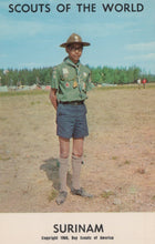 Load image into Gallery viewer, Scout in Surinam wearing a green uniform with a hat, standing in an open field.