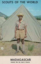 Load image into Gallery viewer, Scout in uniform standing in front of a tent with 'Scouts of the World' and 'Madagascar' text.