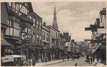 Load image into Gallery viewer, Vintage black and white photo of a street scene with shops and a church spire.