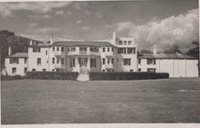 Load image into Gallery viewer, Black and white photo of a large building with a grassy area in front