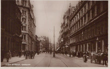 Load image into Gallery viewer, Vintage photograph of a busy street scene in Cardiff, featuring people and horse-drawn carriages.