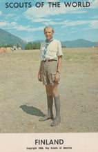 Load image into Gallery viewer, Scout in uniform standing in a field with mountains in the background, labeled 'Scouts of the World, Finland'.