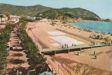 Load image into Gallery viewer, Beach scene with people, cars, and buildings along a road next to a sandy beach.