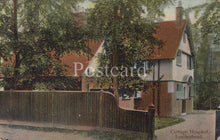 Load image into Gallery viewer, Vintage postcard of a cottage hospital with trees and a fence in the foreground.
