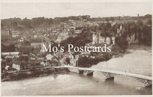Load image into Gallery viewer, Vintage black and white postcard of a town with a bridge over water