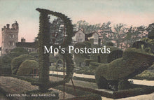 Load image into Gallery viewer, Topiary garden with shaped bushes in the shape of a chair and table, with 'Mo's Postcards' text overlay.