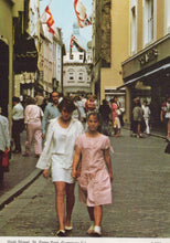 Load image into Gallery viewer, Two women walking down a busy street with shops and people in the background.
