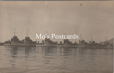 Vintage black and white photograph of naval ships docked at a harbor 