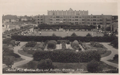 Vintage black and white photo of a bowling green and gardens with buildings in the background