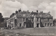 Load image into Gallery viewer, Historic stone building with multiple chimneys under a cloudy sky
