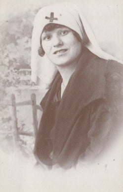 Vintage postcard of a woman wearing a headscarf with a cross emblem.