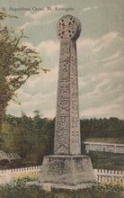 Load image into Gallery viewer, Stone monument with intricate design in a park-like setting

