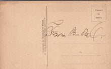Load image into Gallery viewer, Back of a vintage postcard with printed text and signature on brown paper.
