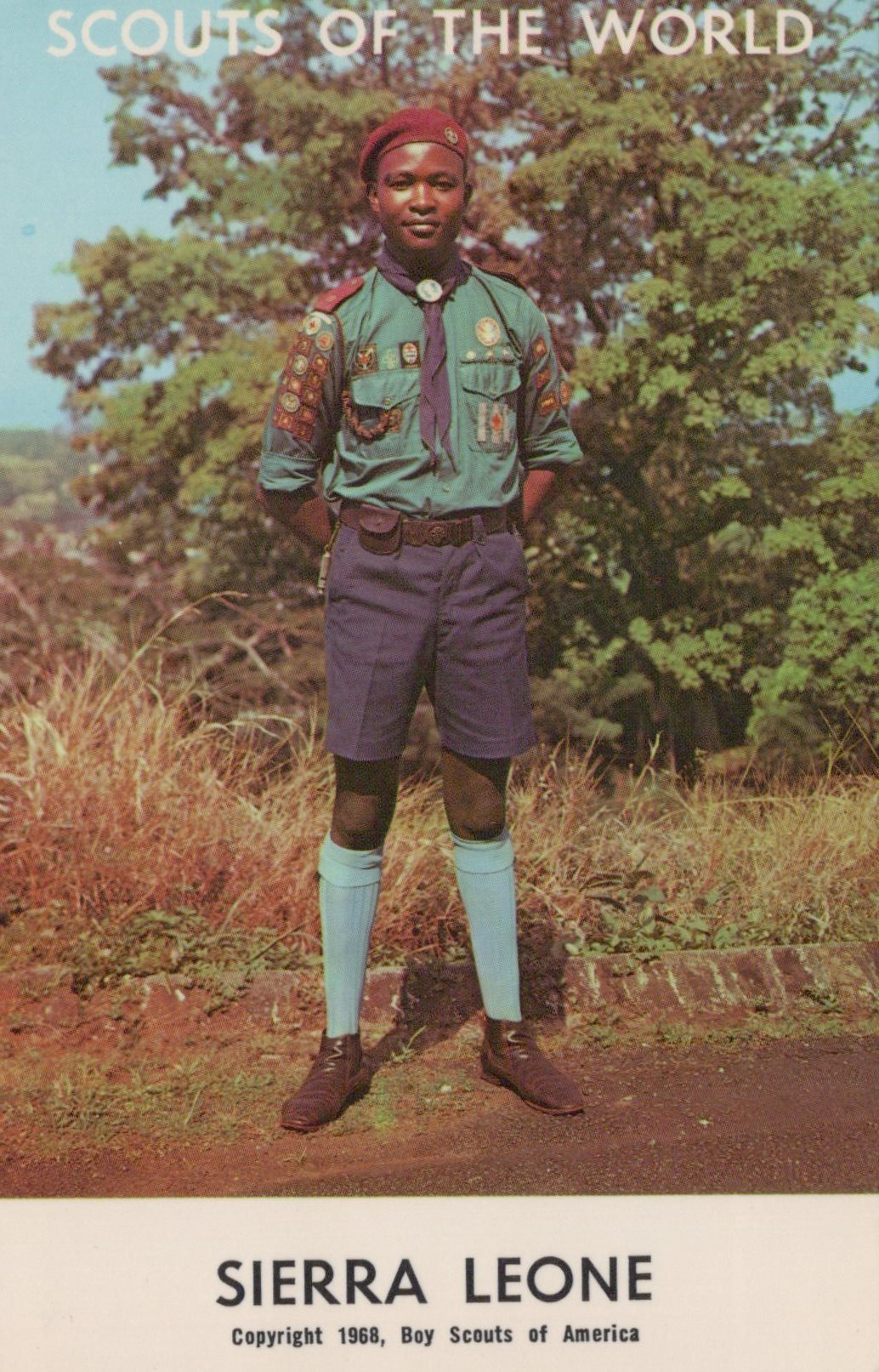 Scout in Sierra Leone wearing a uniform with a tree in the background