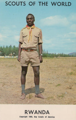 Scout in uniform standing in a field with 'Scouts of the World' and 'Rwanda' text at the top.