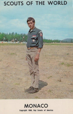 Scout in uniform standing in a field with 'Scouts of the World' and 'Monaco' text on a vintage-style cover.