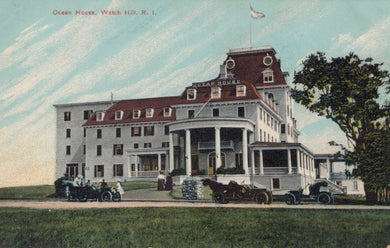 Historic hotel building with vintage cars and people in front, likely from the early 20th century.