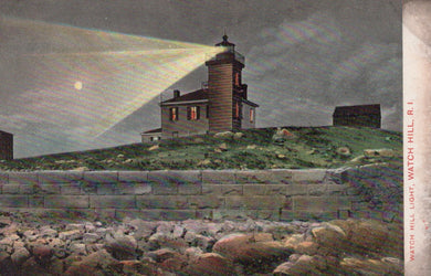 Lighthouse on a hill with a beam of light shining, surrounded by rocks and grass.