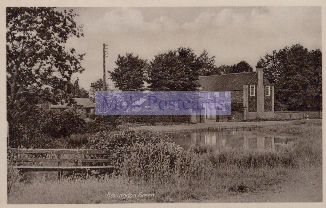 Vintage black and white photo of a pond with trees and buildings in the background
