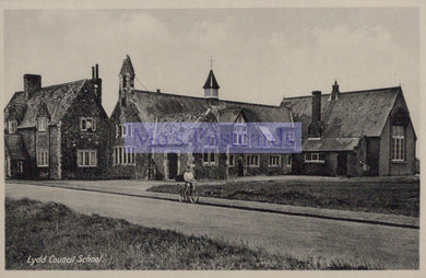 Vintage black and white photo of a school building with a cyclist on the road.