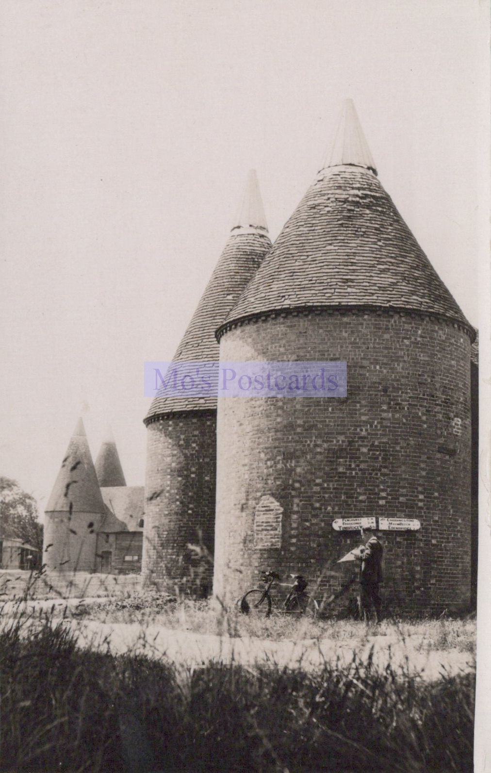 Two oast houses with a bicycle in front, labeled 'No Postcards'.