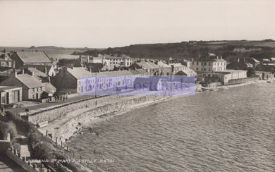Vintage black and white photo of a coastal town with buildings and a seafront.