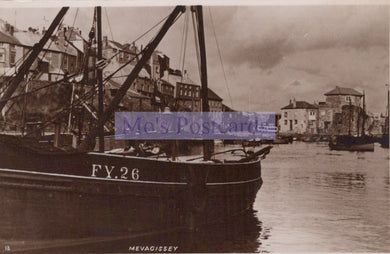 Vintage black and white photograph of a boat with 'FY 26' on it, docked in a harbor with buildings in the background.