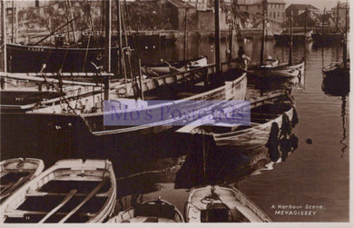 Harbor scene with boats docked along a waterfront, featuring the text 'A Harbour Scene MEVAGISSEY'.