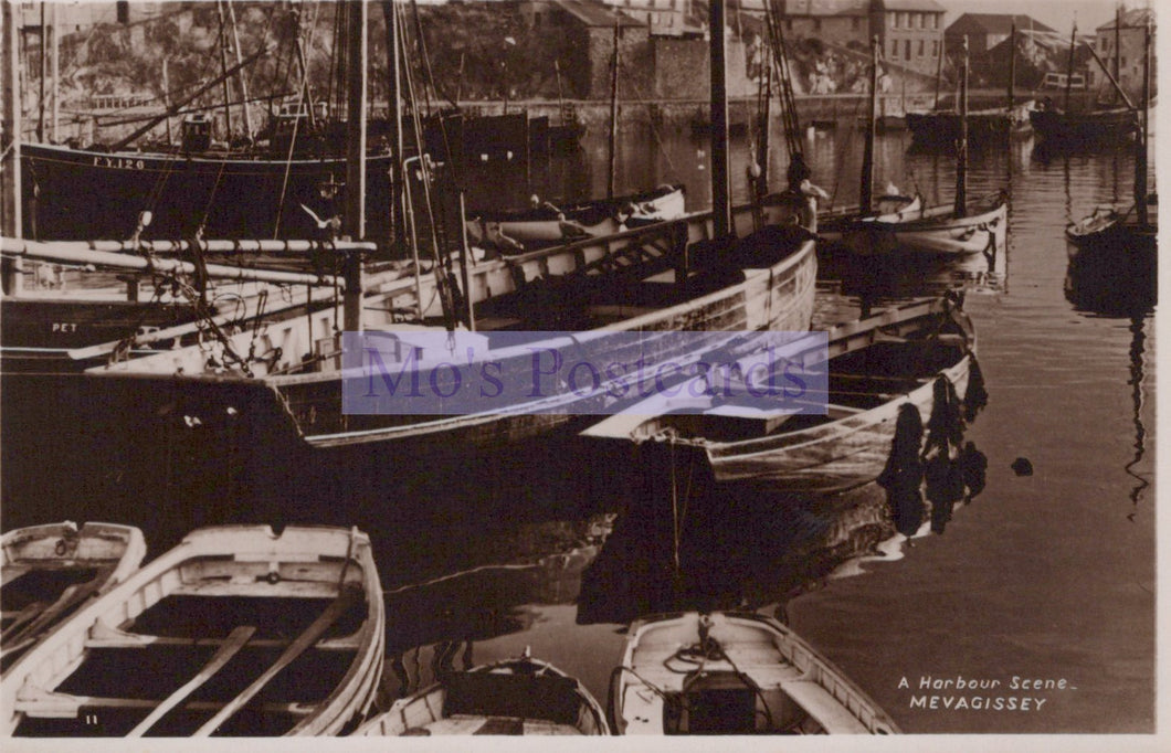 Harbor scene with boats docked along a waterfront, featuring the text 'A Harbour Scene MEVAGISSEY'.