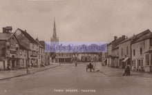 Load image into Gallery viewer, Vintage black and white photograph of a town street with buildings and a church spire.
