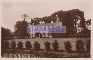 Vintage sepia-toned postcard of a large house with trees and garden.