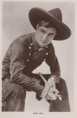 Vintage black and white photo of a person in military uniform with a hat, holding a gun.