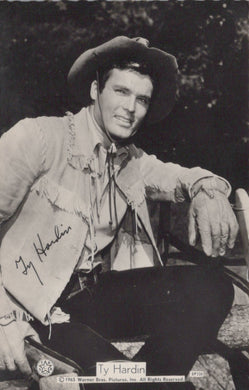 Black and white photo of a person in cowboy attire with a signature on a card.
