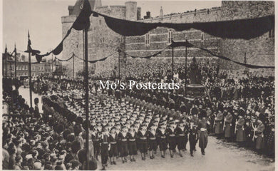 Vintage black and white photo of a formal event with people in uniform and a building in the background.