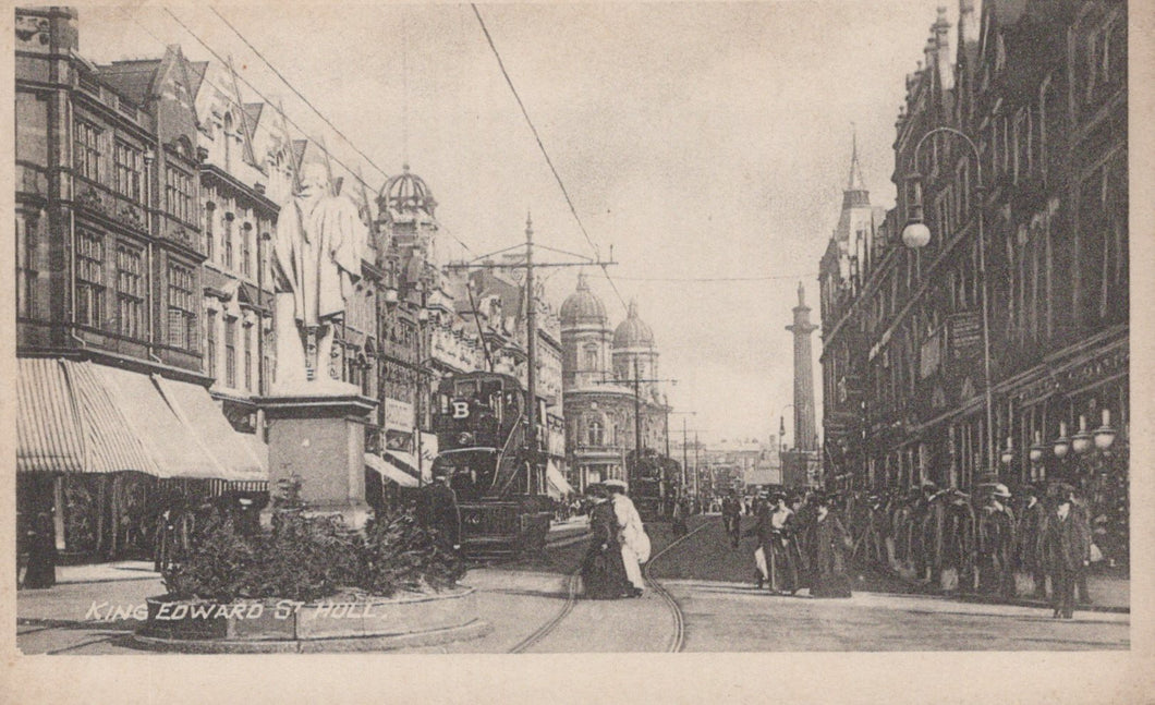 Vintage black and white photograph of a city street with pedestrians and buildings.