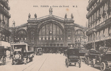 Vintage postcard of Gare du Nord in Paris with early automobiles and trams.