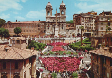 Stairs with pink flowers and people in a cityscape with buildings and blue sky