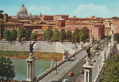 Panoramic view of a cityscape with a large building and a bridge over a river.