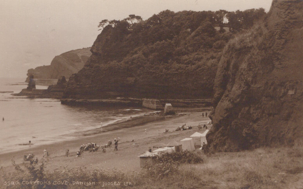 Vintage photograph of a coastal scene with cliffs, beach, and people.