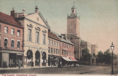 Vintage postcard of a town square with a clock tower and buildings.
