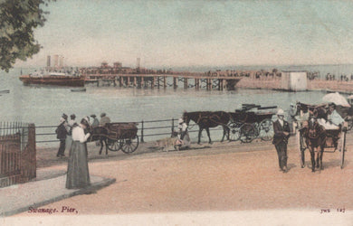 Vintage postcard of Swanage Pier with people and horse-drawn carriages.