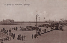 Load image into Gallery viewer, Vintage black and white photo of a promenade with people and vehicles, featuring text &#39;The Baths and Promenade, Hastings&#39;.
