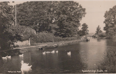 Vintage black and white photo of a canal with boats and ducks, surrounded by trees.