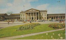 Load image into Gallery viewer, Historic building with a large lawn and flower bed in front, vintage cars parked around.
