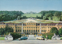 Load image into Gallery viewer, Large classical building with a garden and statues, vintage cars in front
