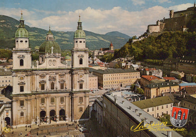 Historic cityscape with prominent building and mountains in the background