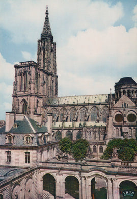 Large cathedral with a tall spire under a blue sky with clouds