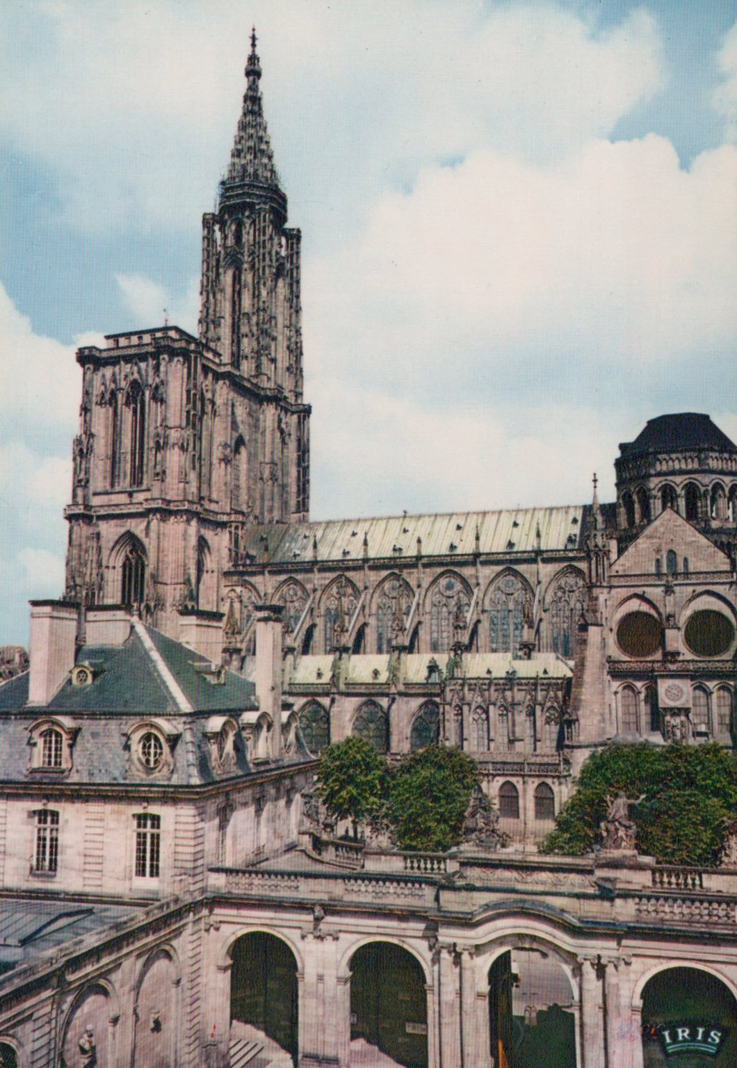 Large cathedral with a tall spire under a blue sky with clouds