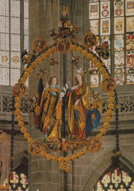 Decorative stained glass window with religious figures and intricate gold detailing in a cathedral setting.